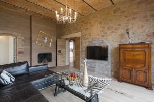 een woonkamer met een bank, een tv en een open haard bij Villa Marghi in Magione