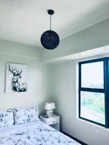 a bedroom with a bed and a window at Stunning Tropical resort condo in Mactan