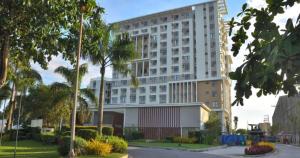 a large white building with palm trees in front of it at Stunning Tropical resort condo in Mactan