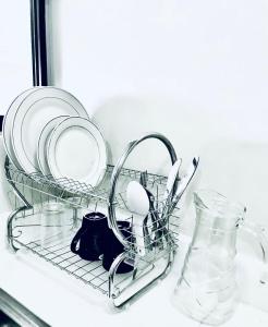 a dish rack with plates and utensils in a sink at Stunning Tropical resort condo in Mactan +11 photos