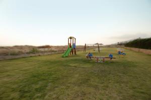 a group of children playing on a playground at Bungalows Bahia de la Plata in Zahara de los Atunes