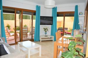 - un salon avec des rideaux bleus et un canapé dans l'établissement LA FLORIDA, à San Luis de Sabinillas