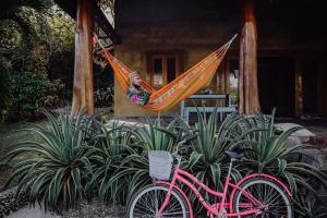 a woman sleeping in a hammock with a pink bike at Bodhi Santa Catalina in Santa Catalina