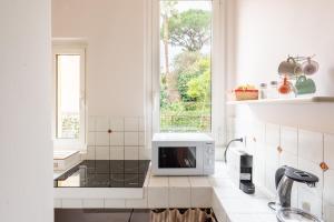cocina con microondas y ventana en SuityRHome RioneMonti56, en Roma