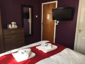 a bedroom with two towels on a bed at Glenmore Guesthouse in Southampton
