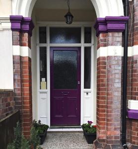 une porte d'entrée violette d'une maison en briques dans l'établissement Glenmore Guesthouse, à Southampton