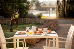 a table with two plates of food and glasses of orange juice at Masseria Mongiò dell'Elefante in Otranto