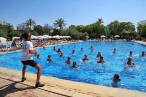 un garçon debout dans une piscine avec un groupe de personnes dans l'établissement Valeria Madina Club - All Inclusive, à Marrakech