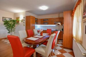 une salle à manger avec une table en bois et des chaises rouges dans l'établissement Villa Lovro in Imotski, private pool, à Gornji Vinjani
