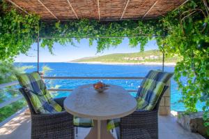 a table and chairs with a view of the ocean at Apartments Ranko in Zavalatica