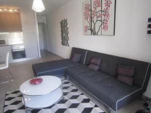 ein Wohnzimmer mit Sofa und Tisch in der Unterkunft Parque Santiago 2 - Casa del Sol in Playa de las Americas