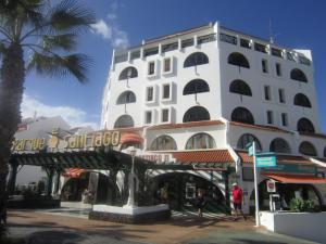 ein großes weißes Gebäude mit einem Brunnen davor in der Unterkunft Parque Santiago 2 - Casa del Sol in Playa de las Americas