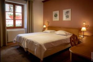 Un dormitorio con una cama grande y una ventana en Hôtel le Saint Nicolas en Riquewihr