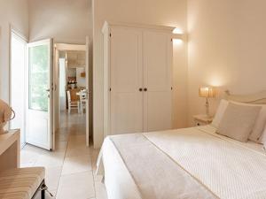 a white bedroom with a bed and a dining room at Masseria Mongiò dell'Elefante in Otranto