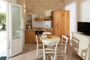 a kitchen with a table and chairs in a kitchen at Masseria Mongiò dell'Elefante in Otranto