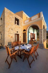 un patio con mesa y sillas frente a un edificio en Secret Paradise Beach Villa en Kalymnos