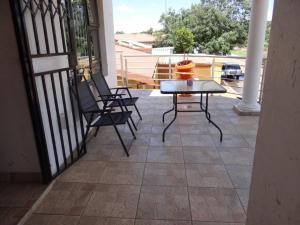 a patio with a table and chairs on a balcony at Flossie B&B in Pimville