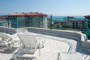 a group of chairs sitting on a patio near the ocean at Stella di Mare Guest House in Ravda