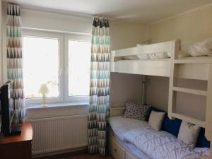a bedroom with bunk beds and a desk and a window at Kleine Harzzeit in Hahnenklee-Bockswiese