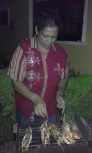 a woman is cooking food on a grill at Grace Villa Bentota in Bentota