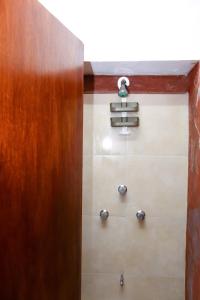 a bathroom with a wooden door and some towels at Hotel y Hostal Casa Don Alfonso in Valladolid