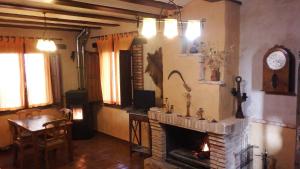 sala de estar con chimenea, mesa y silla en Casa Rural La Ossa en Ossa de Montiel