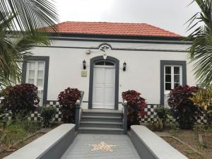 a white house with a blue door and stairs at Villa Vicente in Vila Nova Sintra
