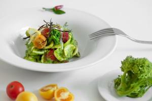 a plate of salad with a fork on a table at Masseria Mongiò dell'Elefante in Otranto