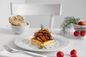 a white plate with a piece of food on a table at Masseria Mongiò dell'Elefante in Otranto