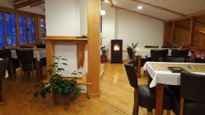 a dining room with tables and chairs and a fireplace at Pansion i Restoran ,, POGLED" in Han Pijesak