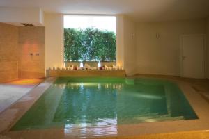 a swimming pool in a room with a large window at Masseria Mongiò dell'Elefante in Otranto