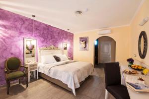 una camera da letto con un letto e una parete viola di Hotel Kalithea a Calitea (Kallithea) Altre 37 foto