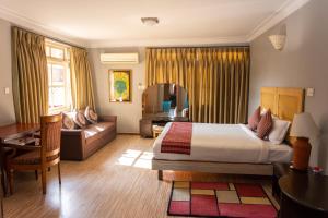 帕坦Shaligram Hotel & Spa的配有床和沙发的酒店房间