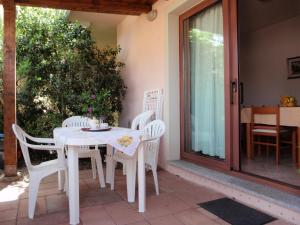 - une table et des chaises blanches sur la terrasse dans l'établissement Borgo Saraceno Mirto 5, à San Pasquale