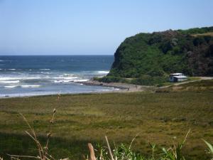 a house on a hill next to the ocean at CABAÑAS MAR BRAVA in Ancud