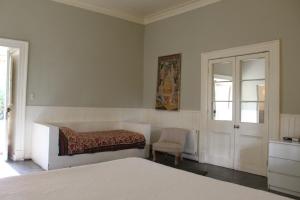 um quarto com uma cama, uma cadeira e uma janela em Hotel Plaza Malloa em Malloa