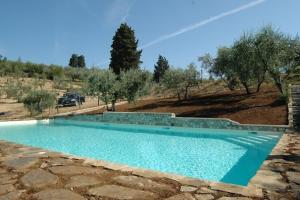 ein blauer Pool in der Mitte eines Feldes in der Unterkunft la Torretta di Villa Borri Chianti Classico in San Casciano in Val di Pesa