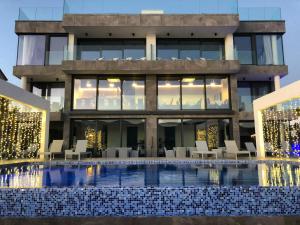 a building with a swimming pool in front of a building at Sky Beach Aparthotel in Marina