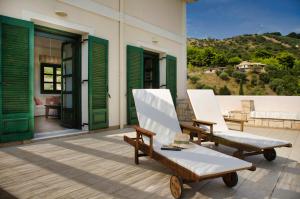 a pair of chairs on the porch of a house at SEAVIEW DAISY HOUSE IN ZAKYNTHOS ISLAND in Vasilikos