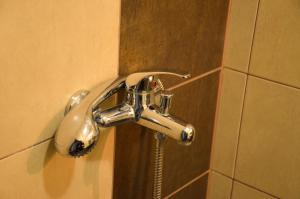 a shower faucet on a wall in a bathroom at Ivanovi Apartments in Burgas