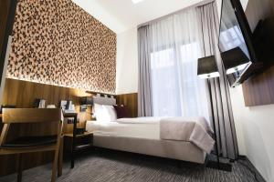 a hotel room with a bed and a window at Best Western Hotel Mariacki Katowice in Katowice