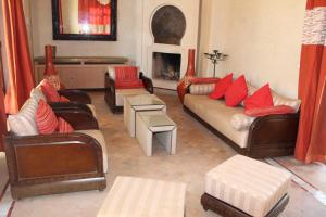 a living room with leather couches and red pillows at Villa entière GOLF MARRAKECH in Marrakesh