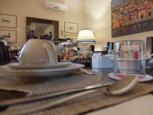 a table with plates and utensils on a table at La Casa di Enrico in Caorle