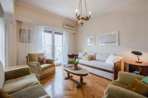 een woonkamer met een bank, stoelen en een tafel bij Retro Apartment at Trendy Exarcheia in Athene