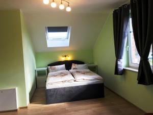 Bodstedt的住宿－Haus Kranichweide，一间位于绿色客房内的卧室,配有一张床