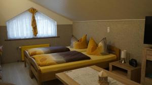 a bedroom with two beds and a window and a table at Pension im Glück Thale in Thale