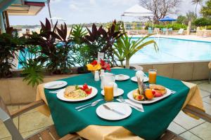 a table with plates of food on it next to a pool at Crown Point Beach Hotel in Crown Point