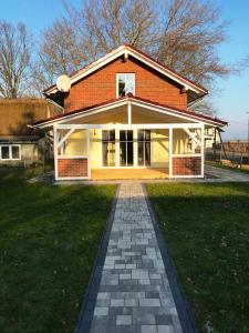 a brick house with a brick pathway in front of it at Haus Kranichweide in Bodstedt