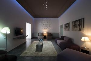 a living room with couches and a tv and a table at Hotel Santa Brigida in Naples