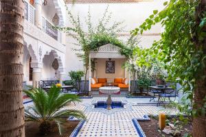 an outdoor courtyard with an orange couch and a fountain at Riad Tahyra in Marrakesh